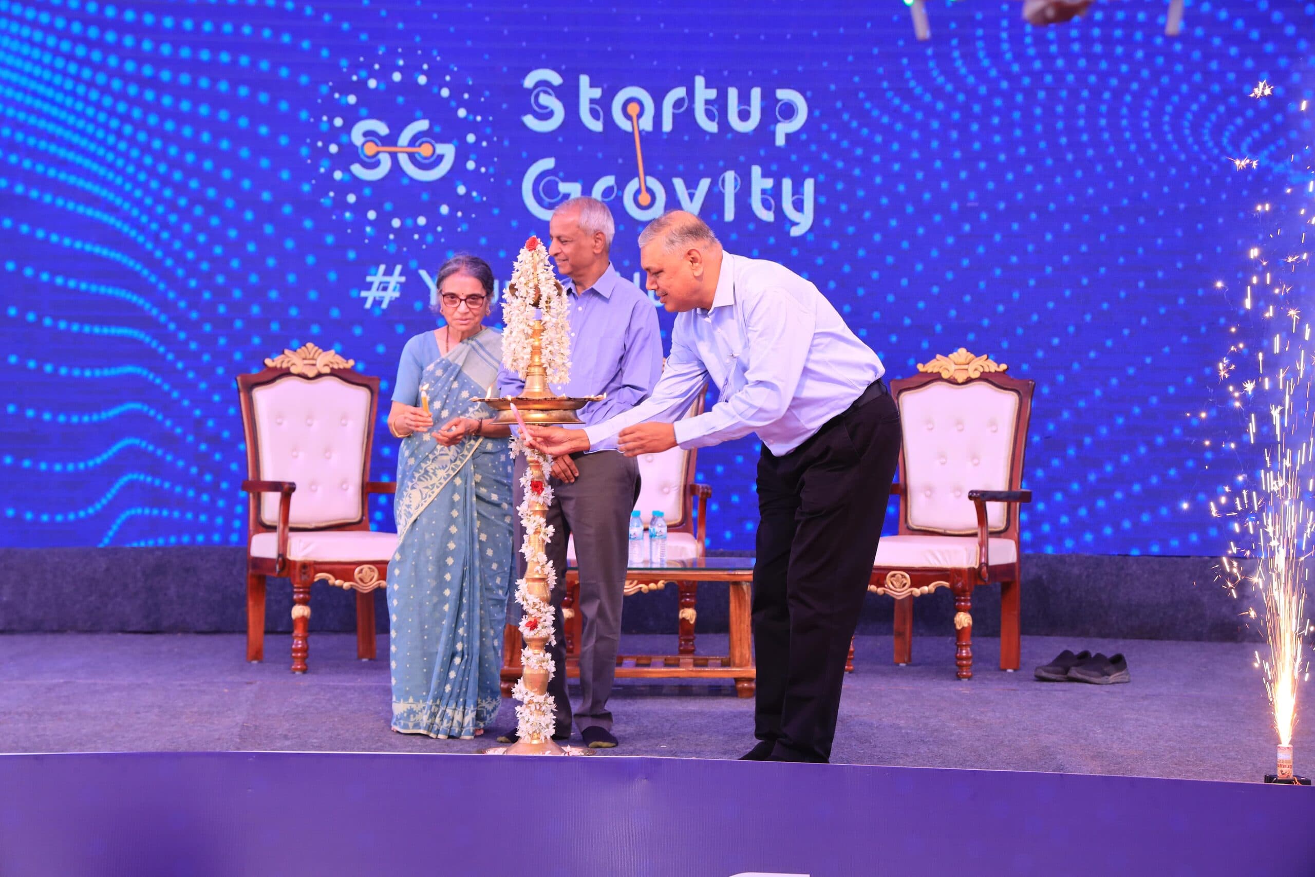 Dignitaries lighting a ceremonial lamp in front of a Startup Gravity LED wall