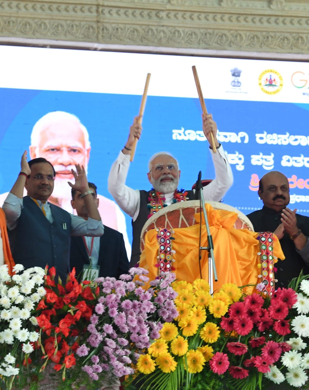 Prime Minister Narendra Modi playing a ceremonial drum on stage
