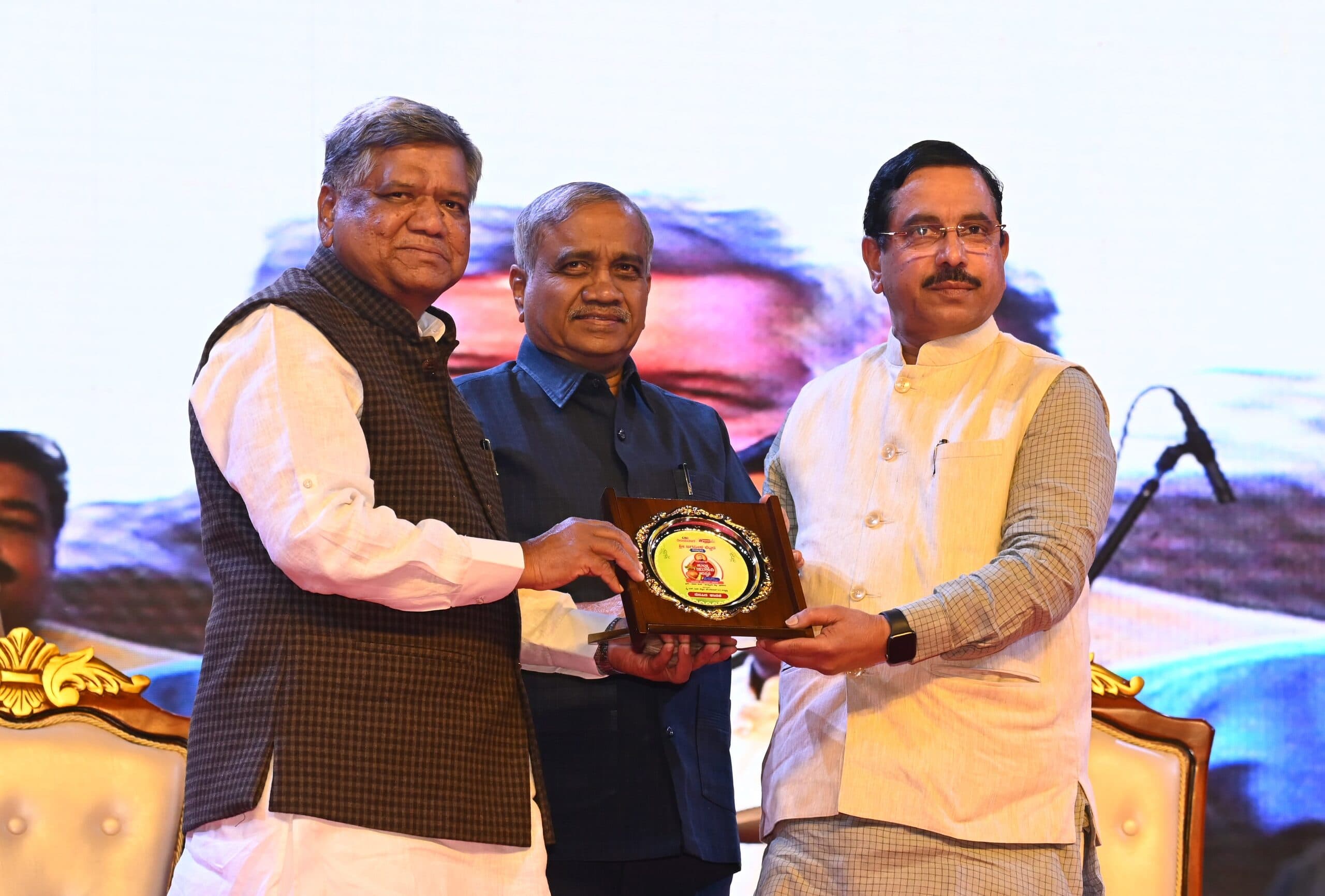 Guests presenting a commemorative memento together on the Ugadi Utsav stage