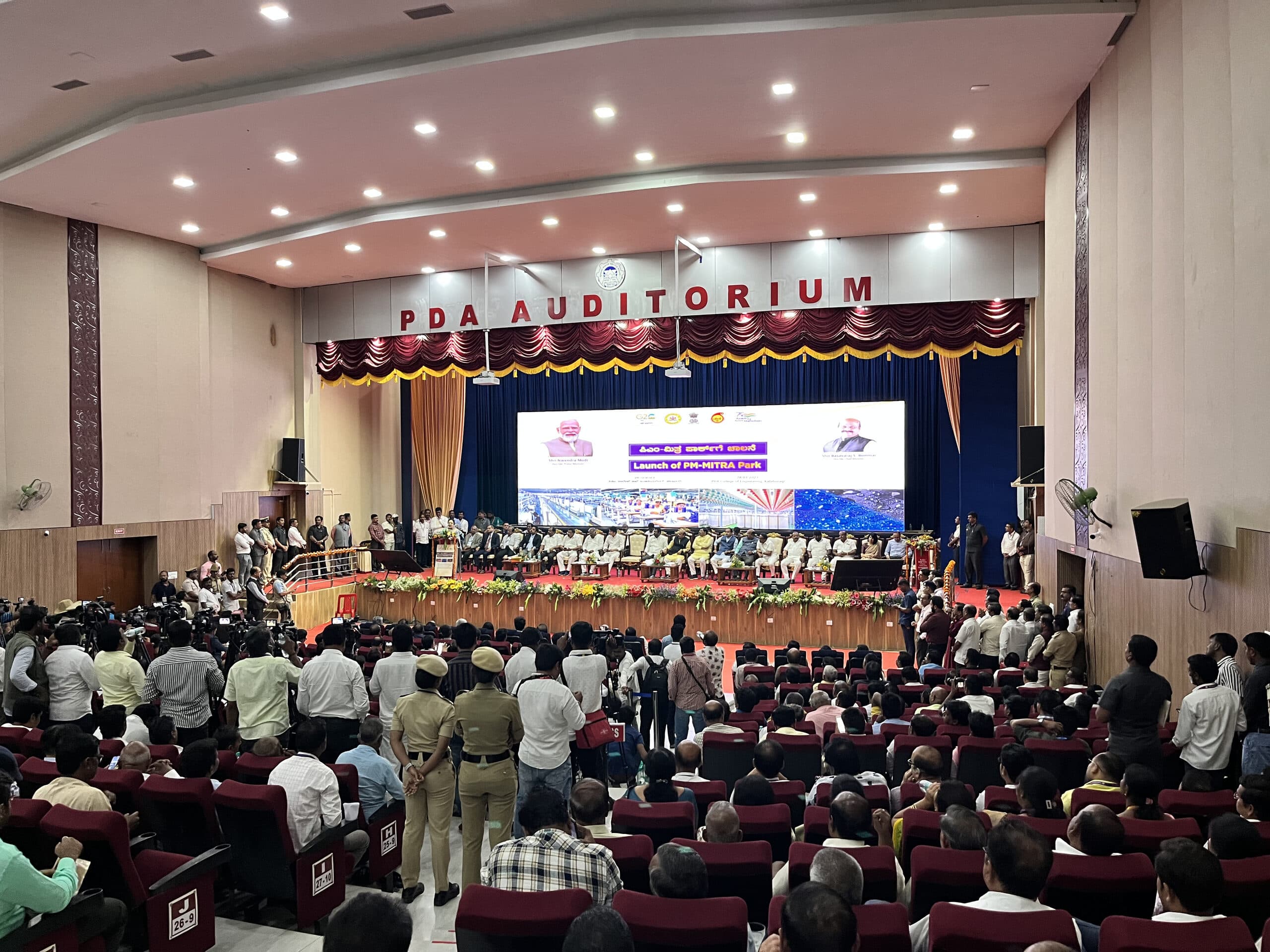 A full auditorium facing a projection stage at the PM MITRA park convention