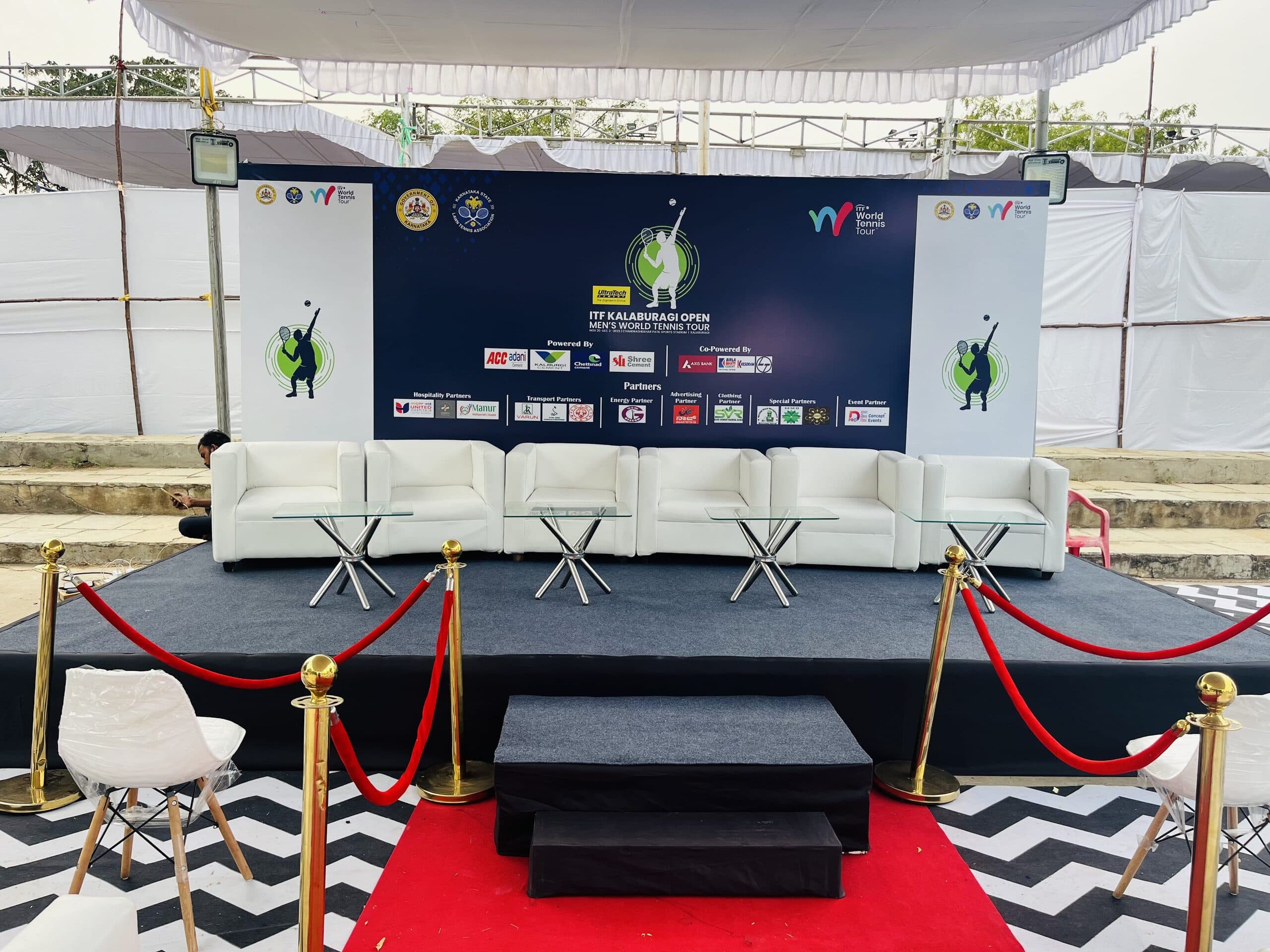 Wide front view of the ITF Kalaburagi Open panel stage and seating