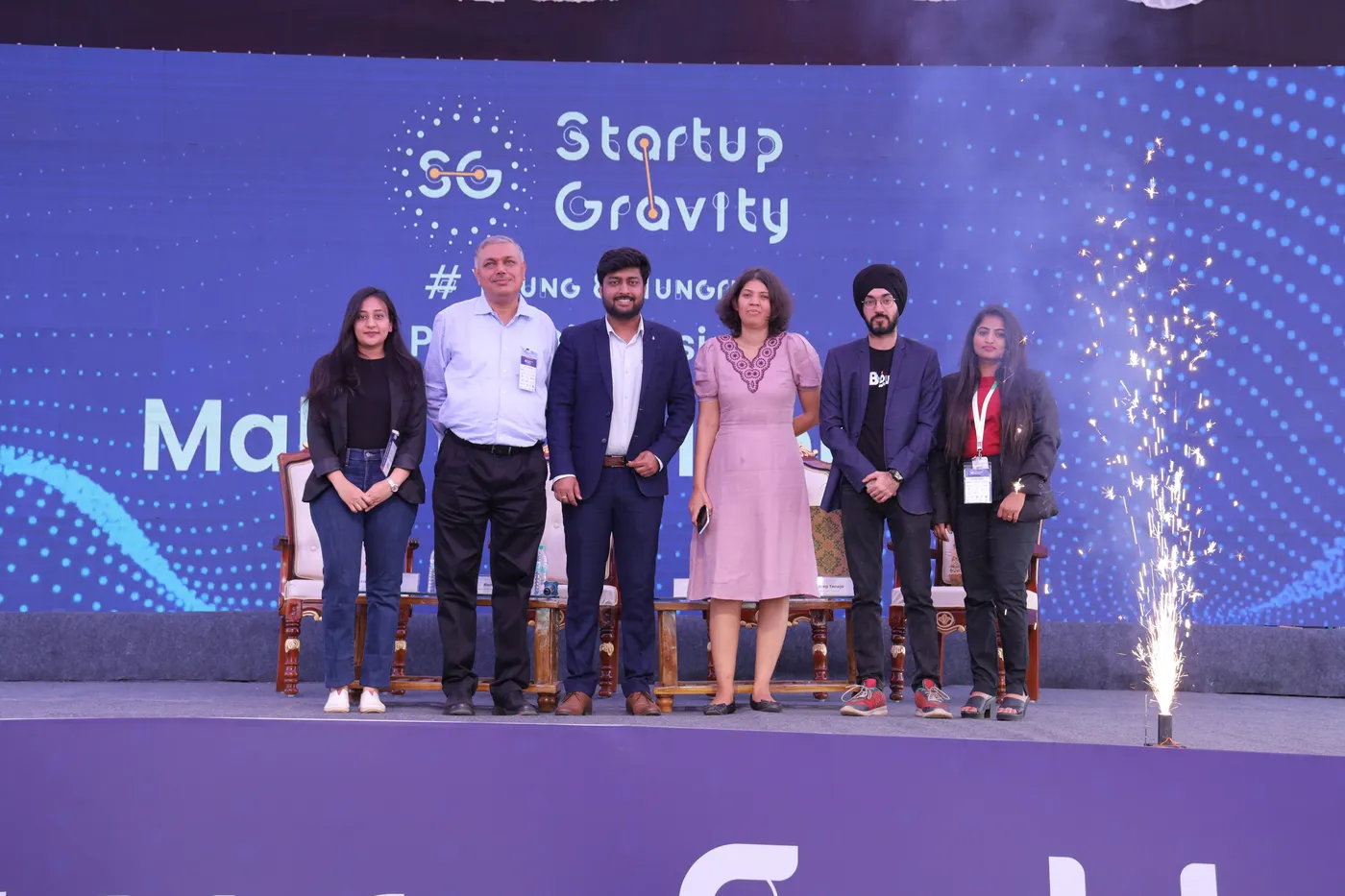 Startup founders on stage with pyrotechnics