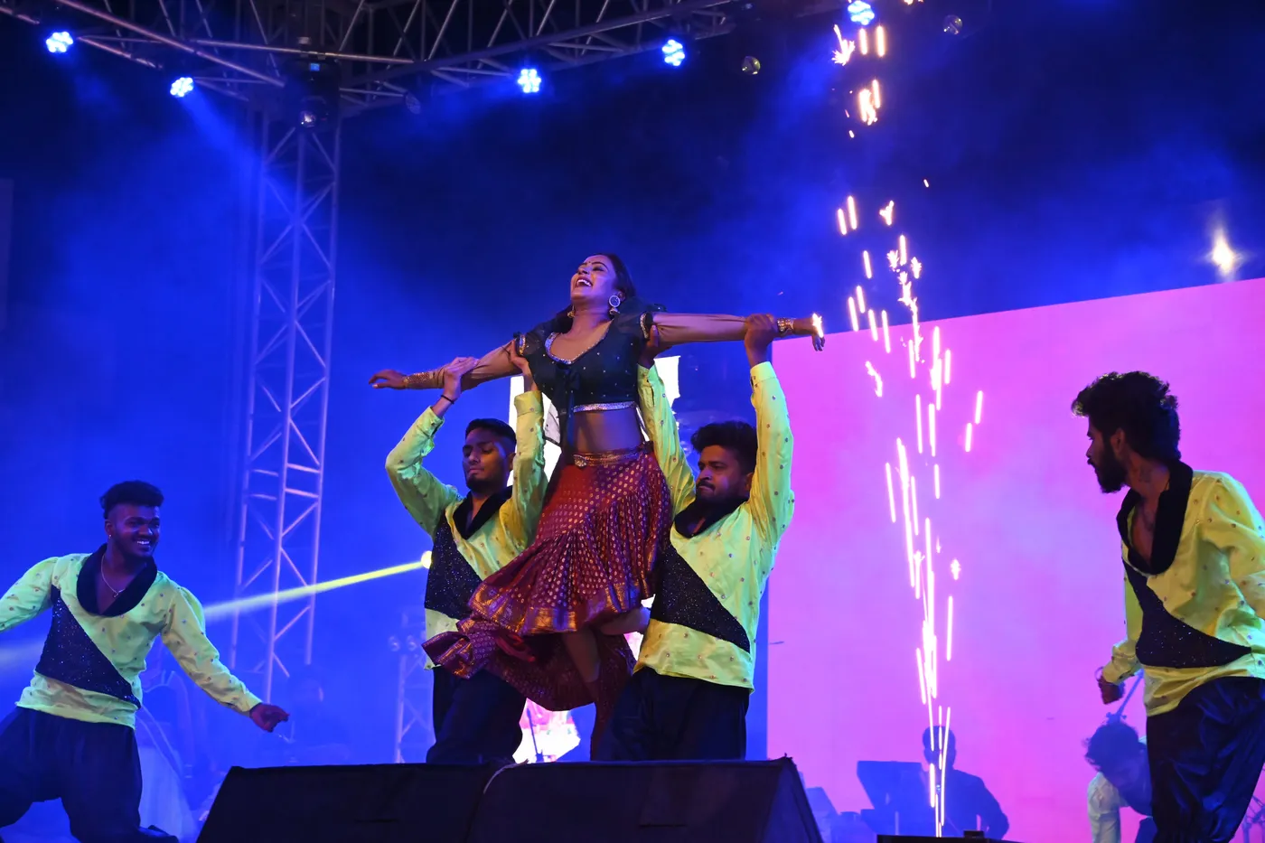 Folk dancers under pyrotechnics on a festival stage