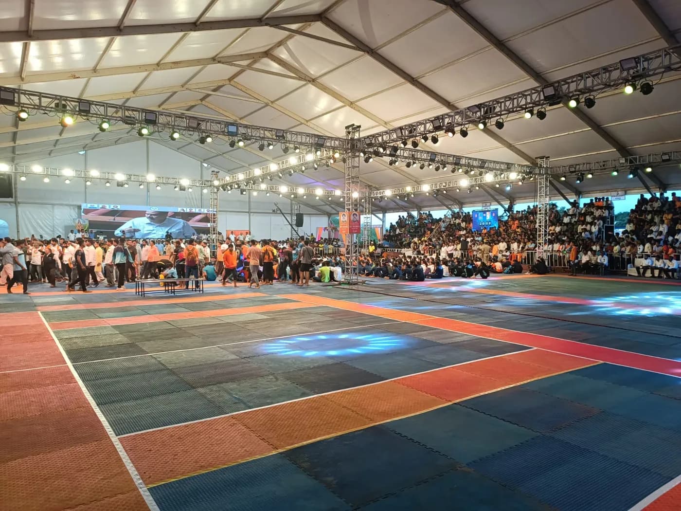 Indoor sports court under a tented arena with a full crowd