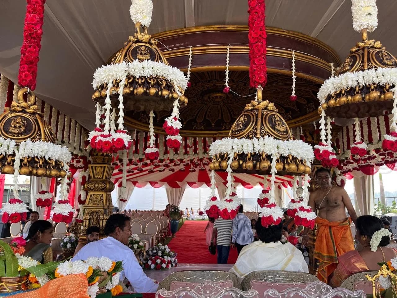 Floral mandap dressed in white garlands and red roses